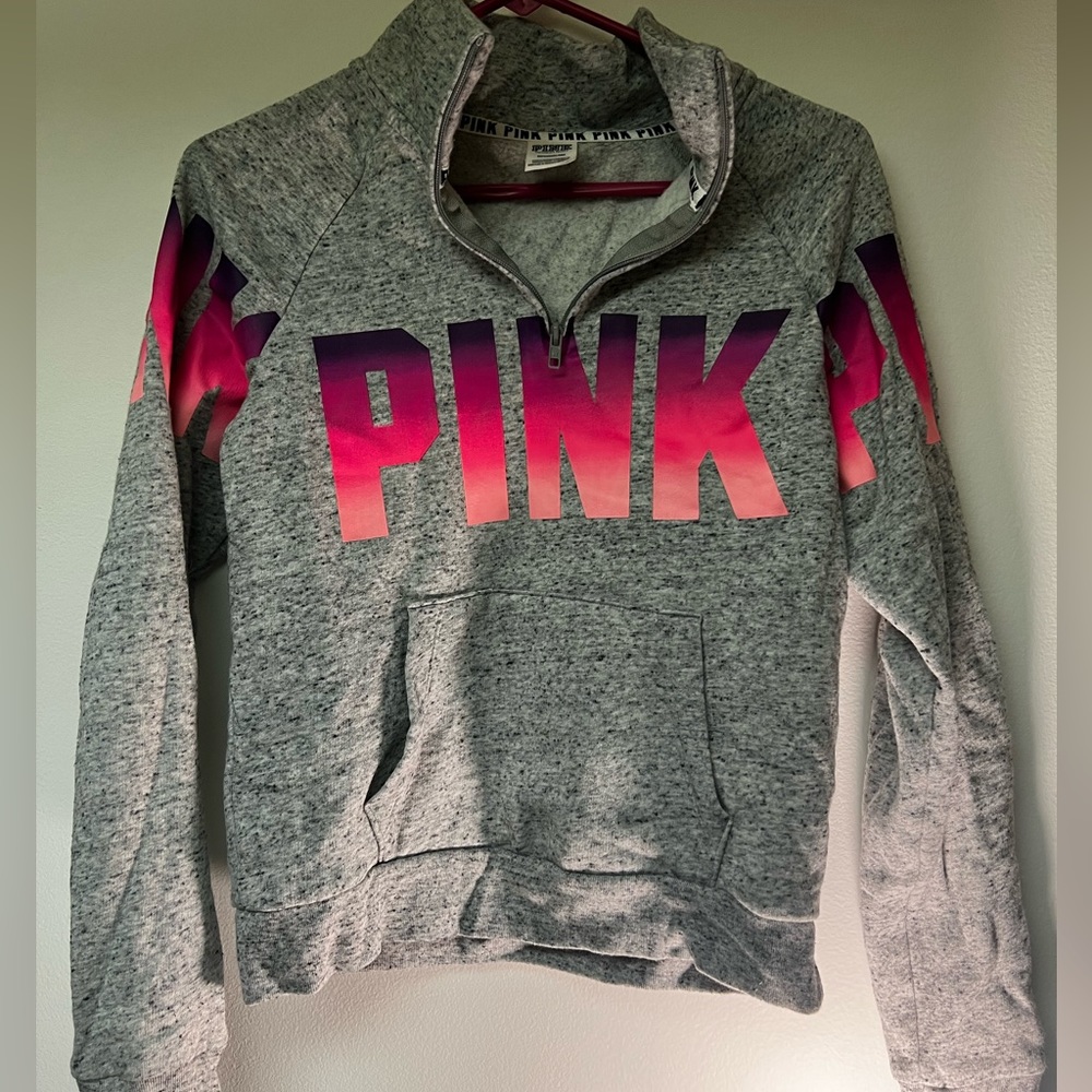 Pink & purple gradient pink logo with a dotted grey background and is 3/4 zip up